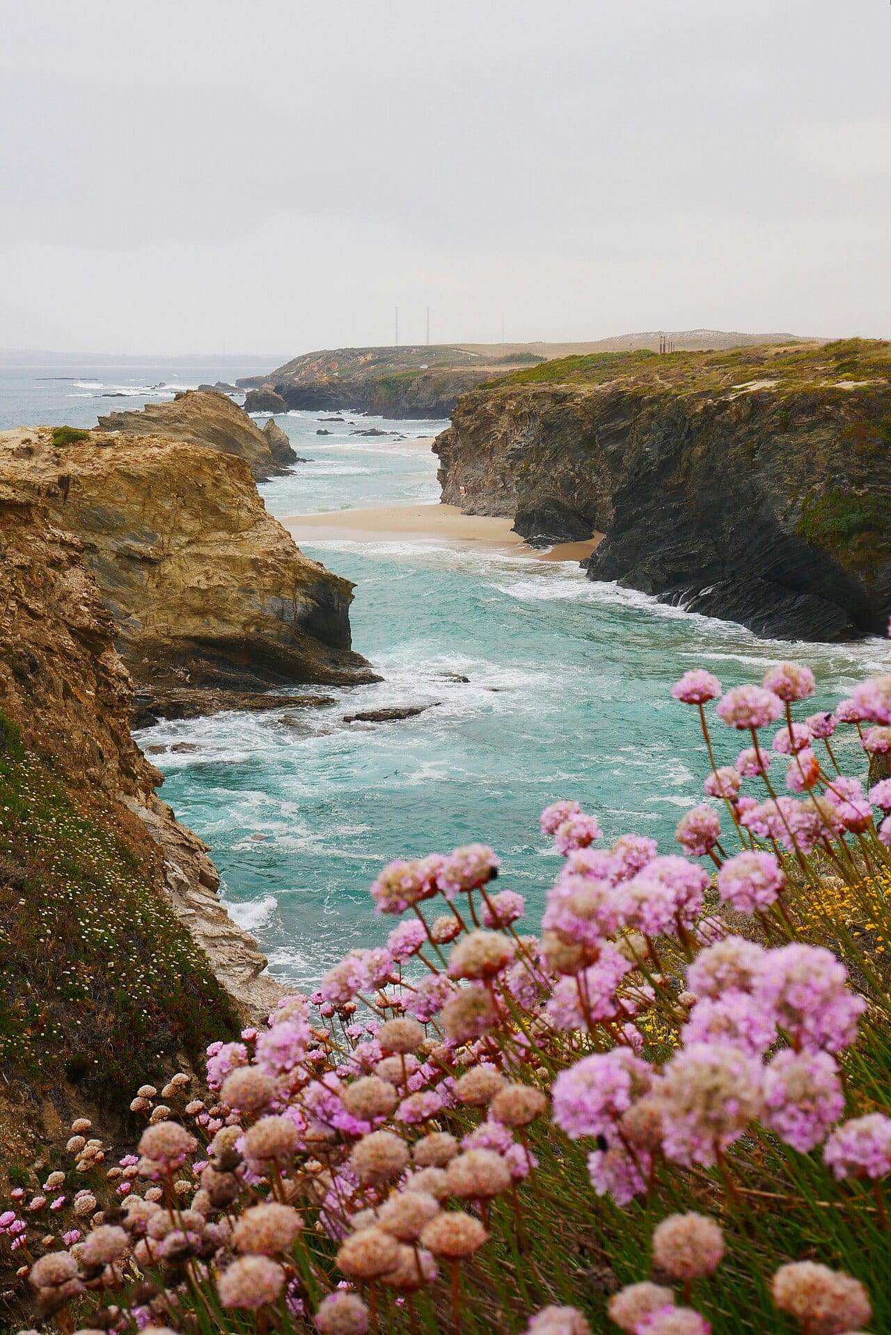Praia da Samoqueira in winter — serene rocky cove with stone formations and calm sea near Porto Covo